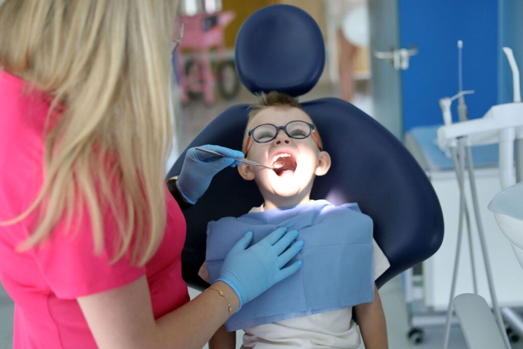 dentystka sprawdza zęby na wizycie kontrolnej